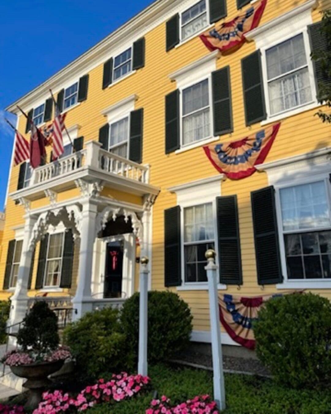 Yellow historic building decorated with patriotic bunting in Exeter, New Hampshire.